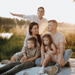 Familia con tres infancias disfrutando un dulce momento en el pasto
